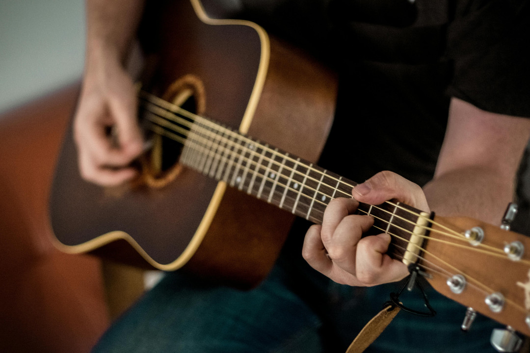 man-playing-brown-acoustic-guitar-image
