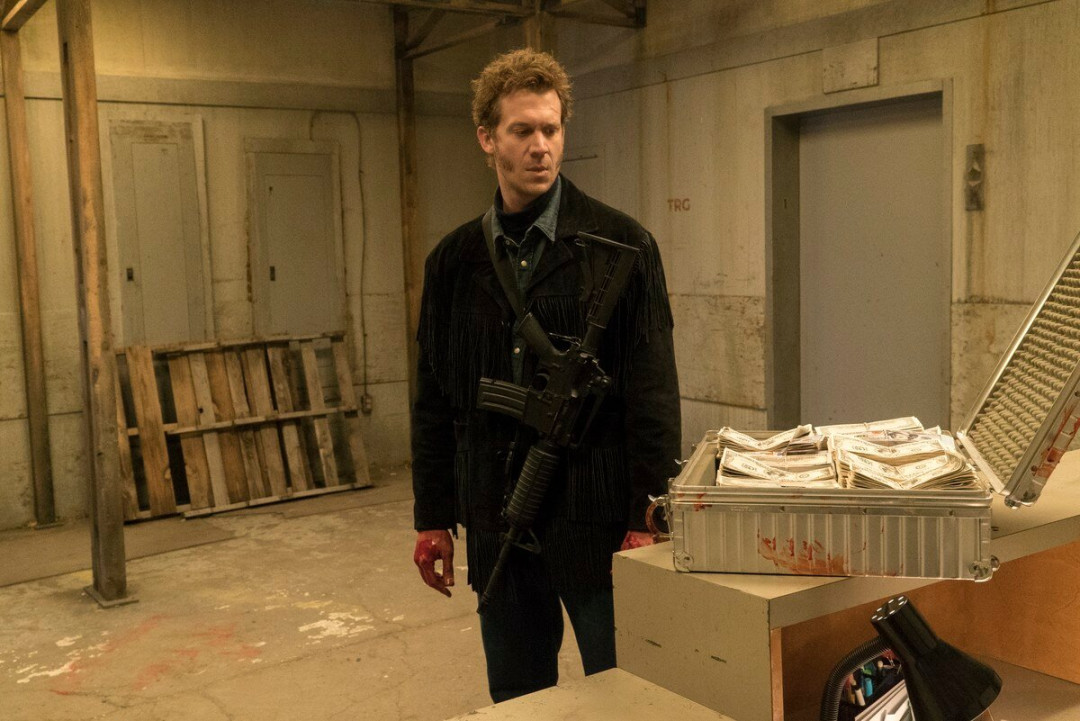man-with-rifle-looking-at-briefcase-full-of-money-in-abandoned-warehouse-image