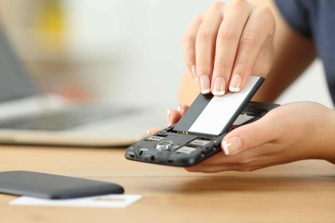 hands changing battery in a phone