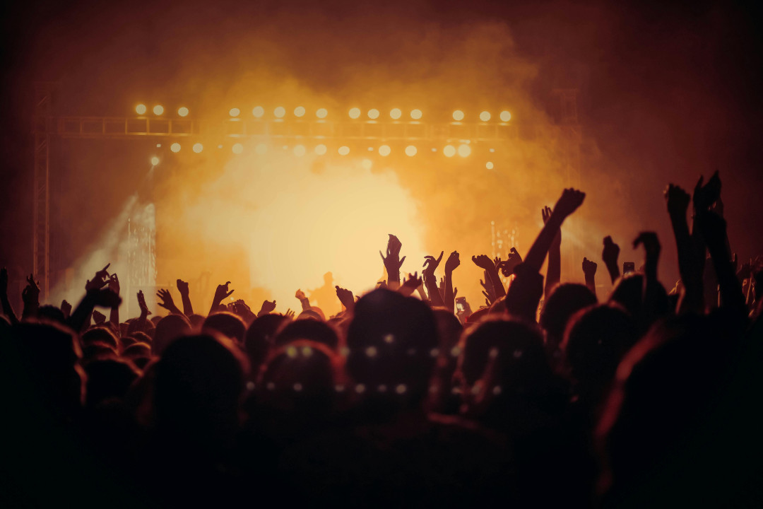 concert-crowd-with-hands-raised-in-bright-stage-lights-image