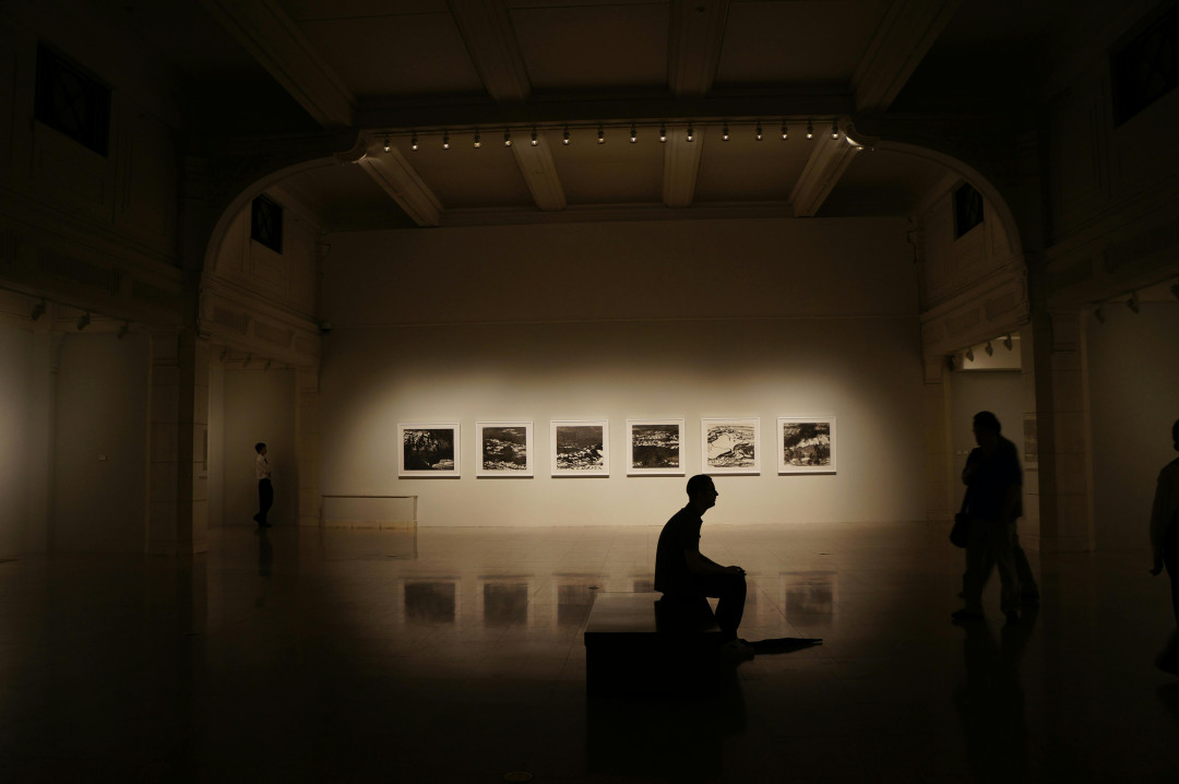 man-sitting-in-darkened-museum-hall-grumpy-guide-image
