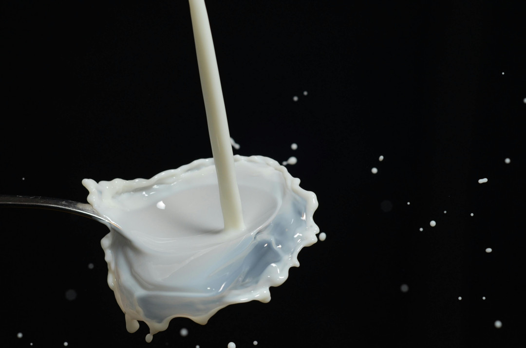milk-splash-in-a-spoon-on-black-background-image