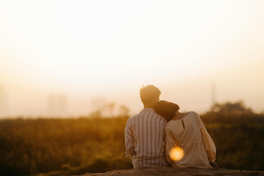 couple-sitting-together-at-sunset-romantic-moment-image