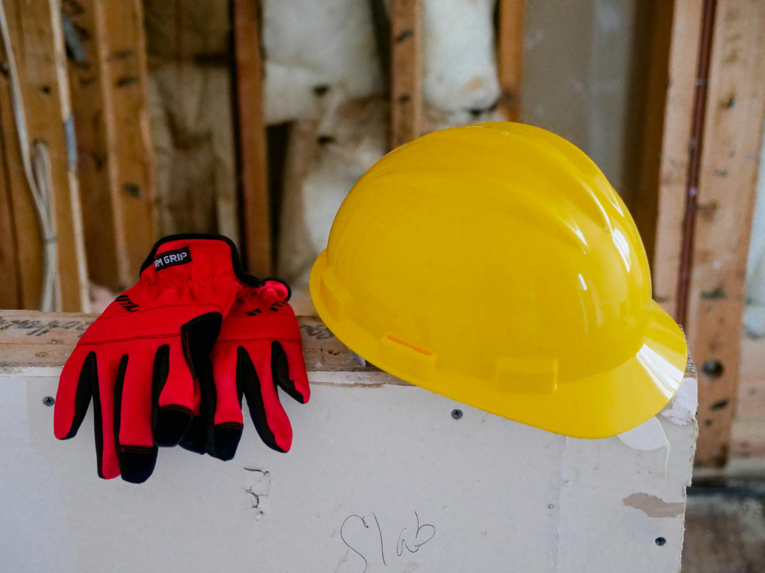 yellow-hard-hat-and-red-protective-gloves-close-up-image