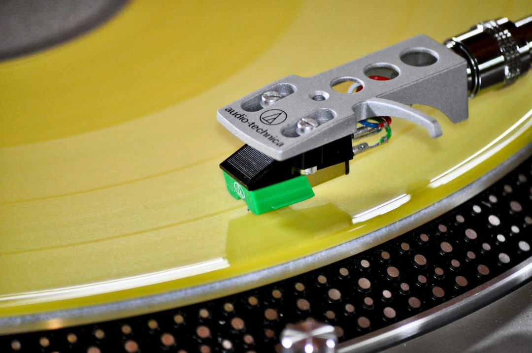 close-up-yellow-vinyl-record-playing-on-turntable-with-needle-image
