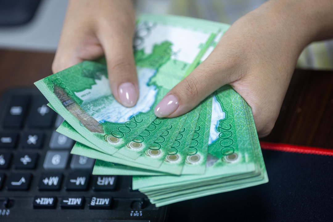 hands-counting-kazakh-tenge-near-keyboard-image