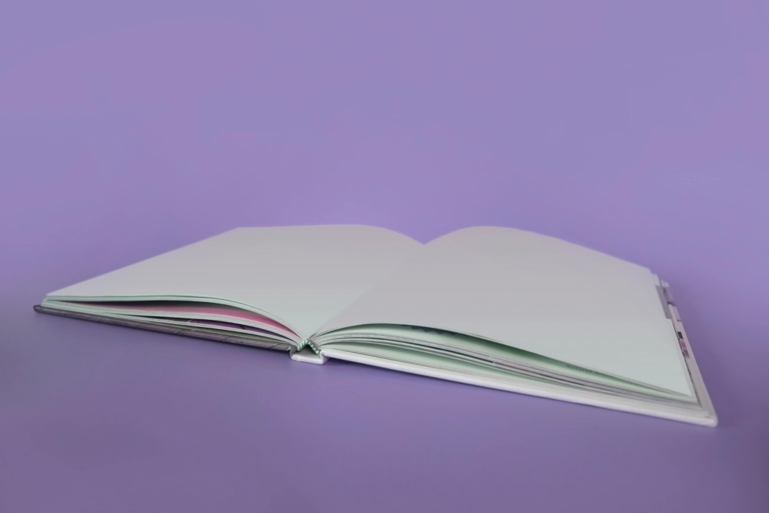 open-book-on-purple-surface-image