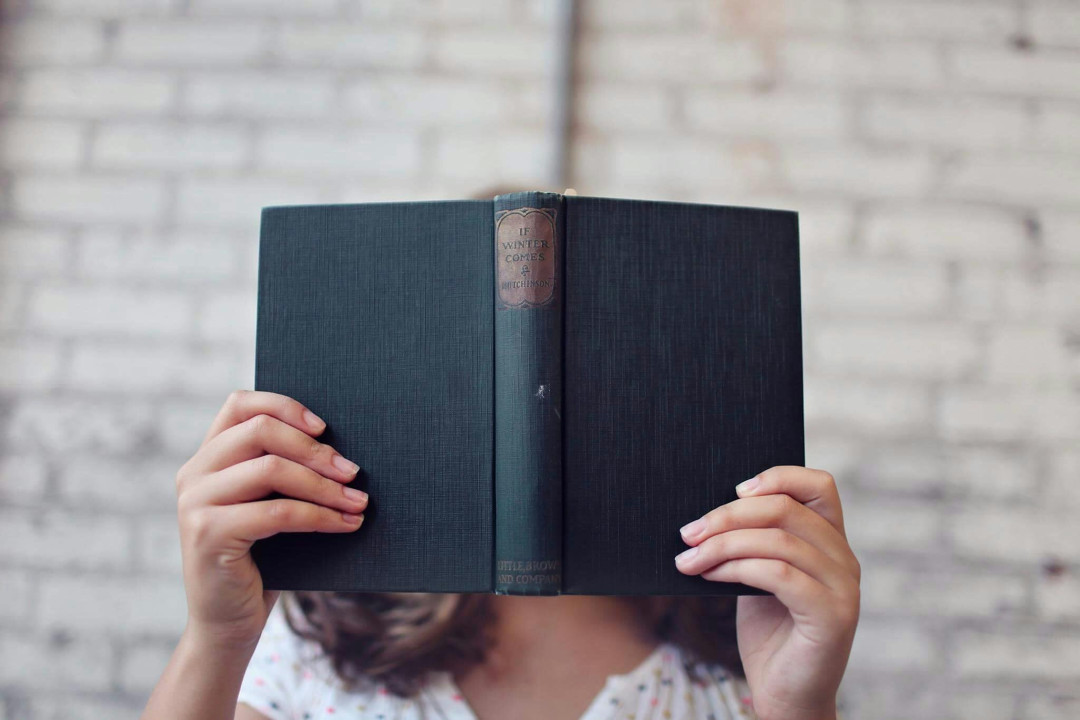 woman-holding-a-book-reading-indoor-image