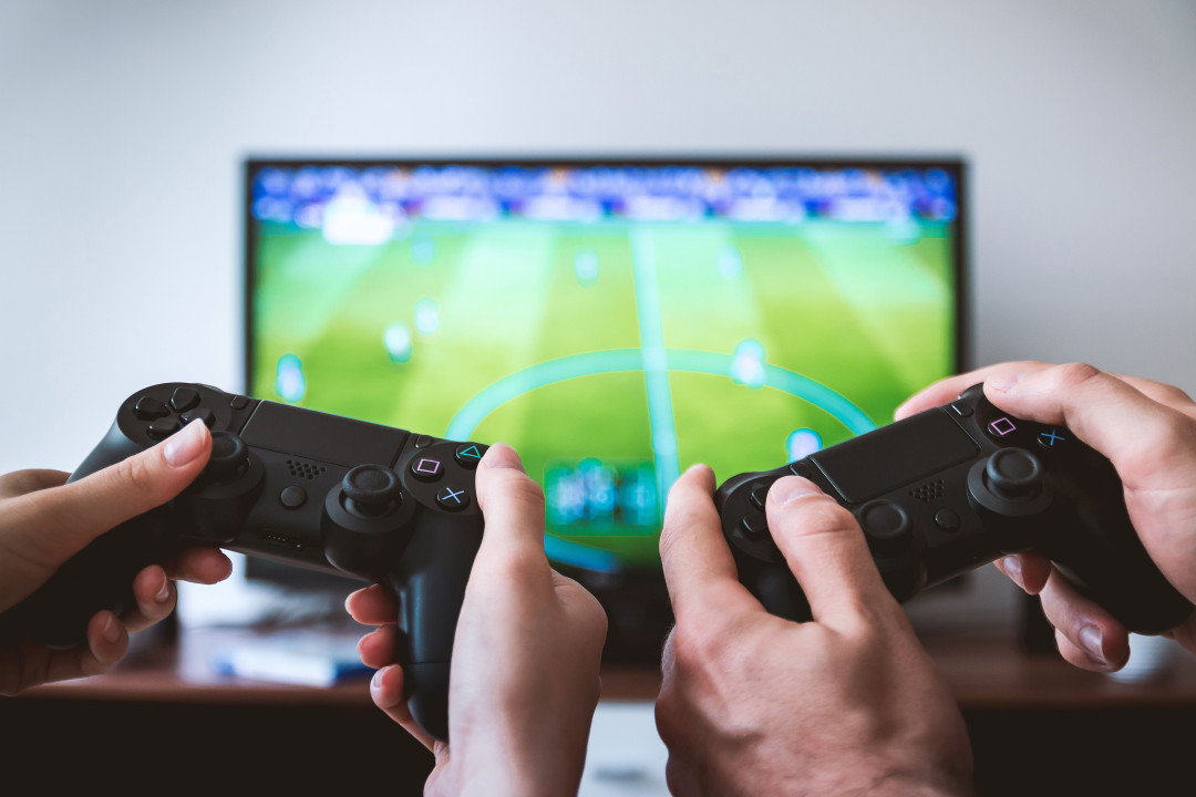 two-people-holding-black-game-consoles-image