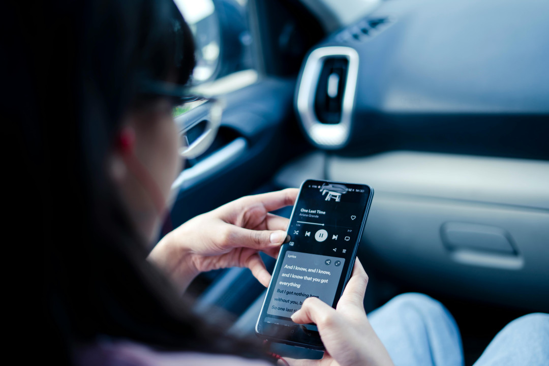 woman-holding-phone-with-song-lyrics-on-screen-image